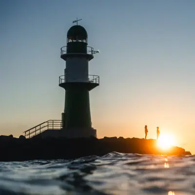 Lighthouse Warnemünde Lighthouse standing in the water under a clear sky.