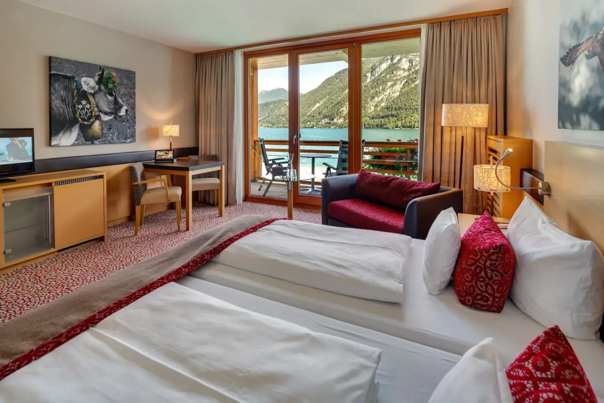 Room with lake view A room with a view of a lake and mountains.