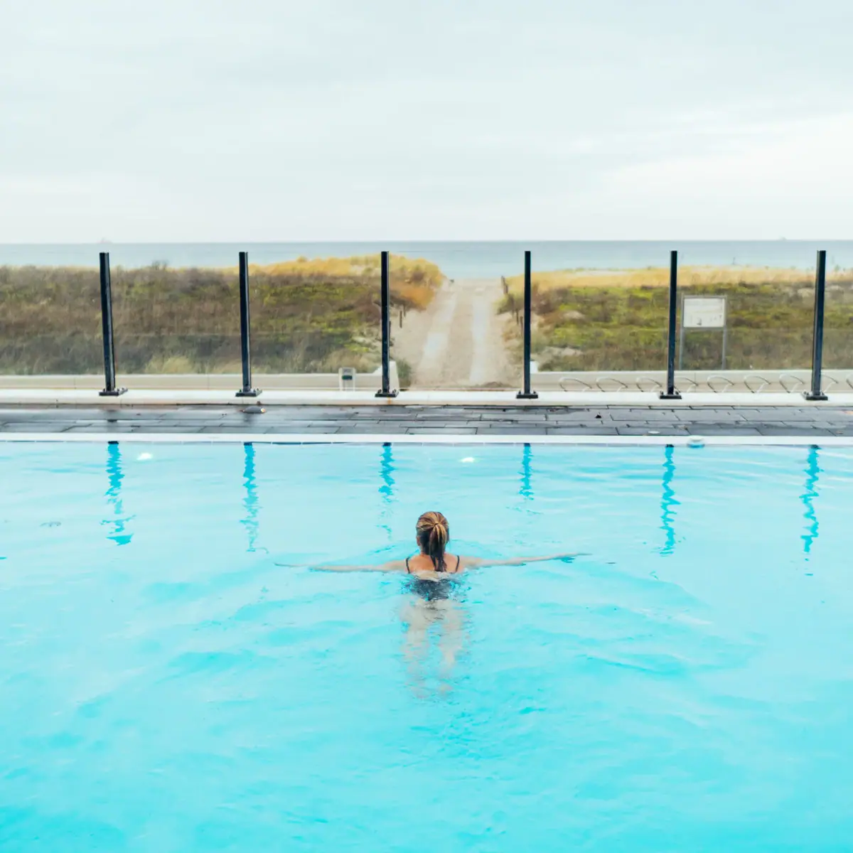 Outdoor pool at the aja Warnemünde Woman swimming in an outdoor pool.