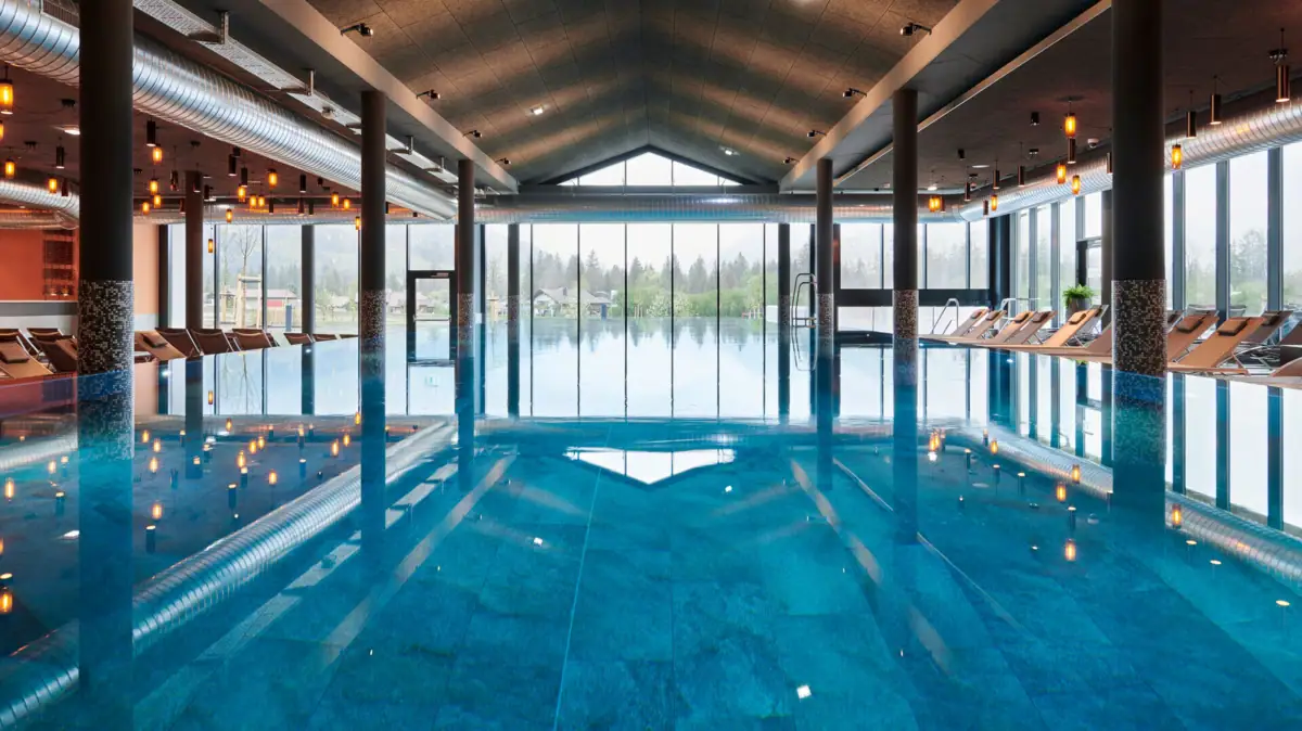 Large indoor pool with high ceiling and large windows.