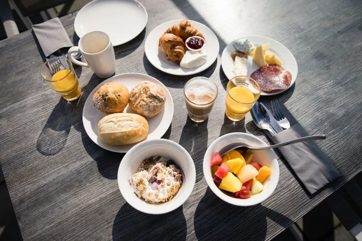 Breakfast at JEDERMANNS A table laden with plates of food and drinks.