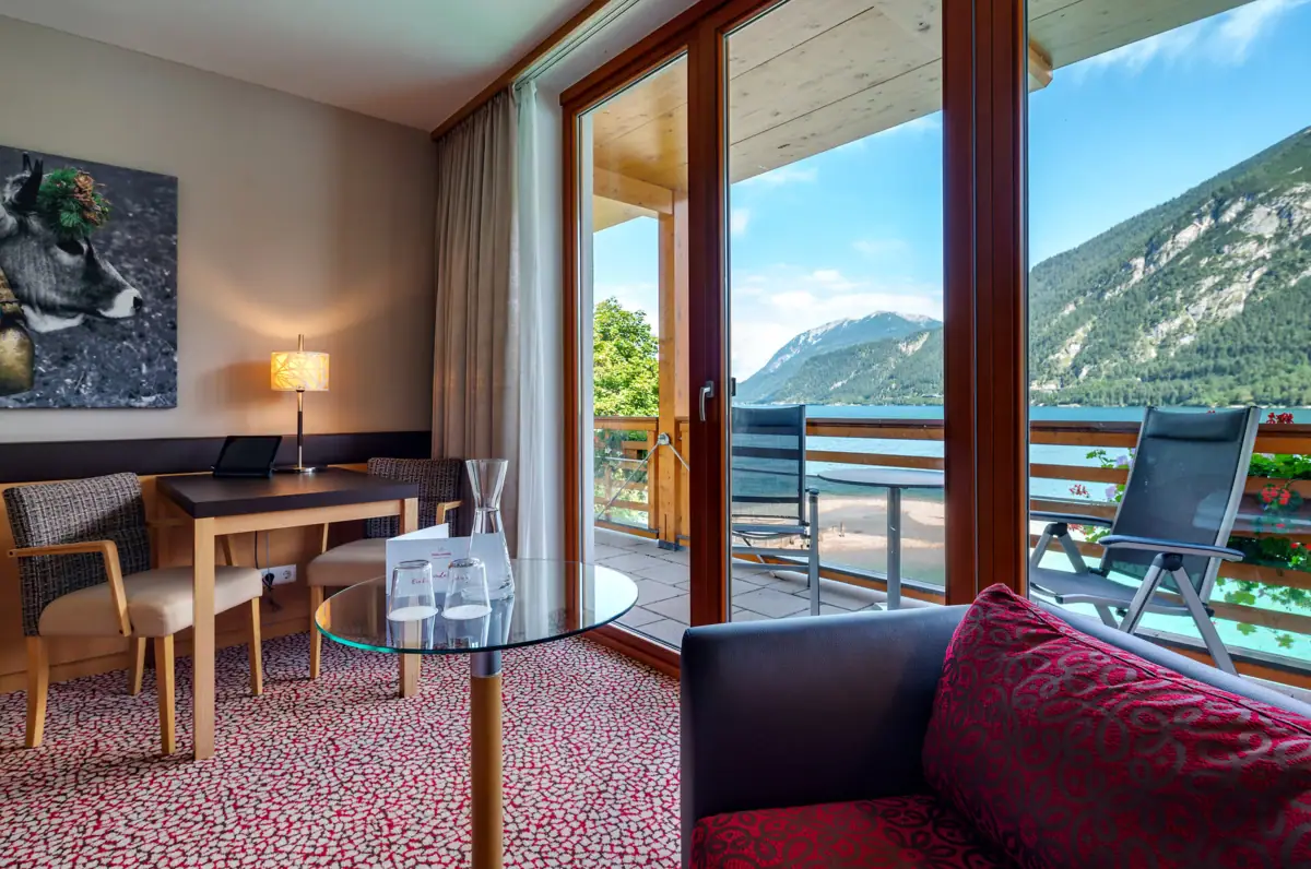 Room with lake view A room with a glass table and chairs.