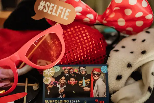 Accessories for a photo box on a table and a photo in the centre with people celebrating.