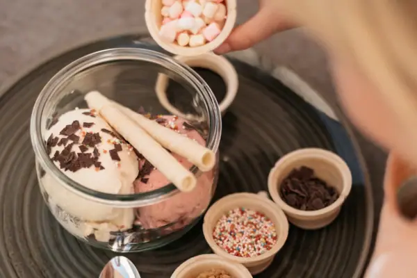 A child sprinkles marshmallows on an ice cream sundae at aja Garmisch-Partenkirchen.
