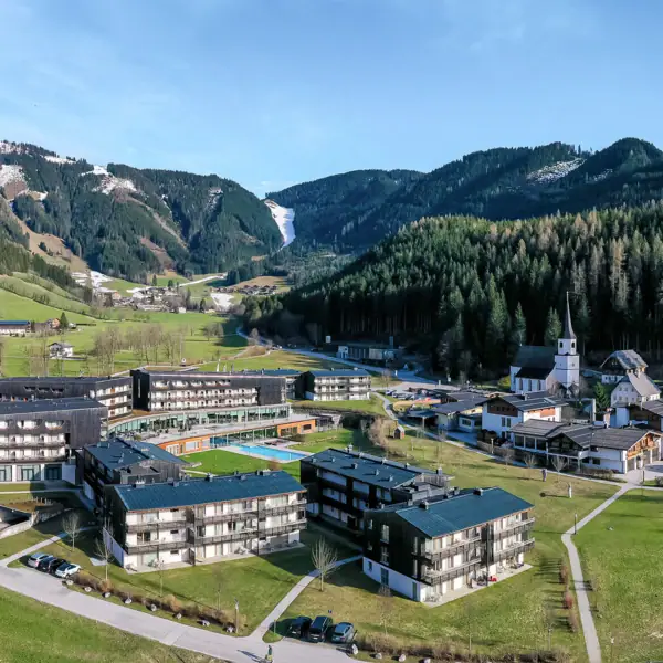 Werfenweng mountain resort A group of buildings in a village in front of a mountain.