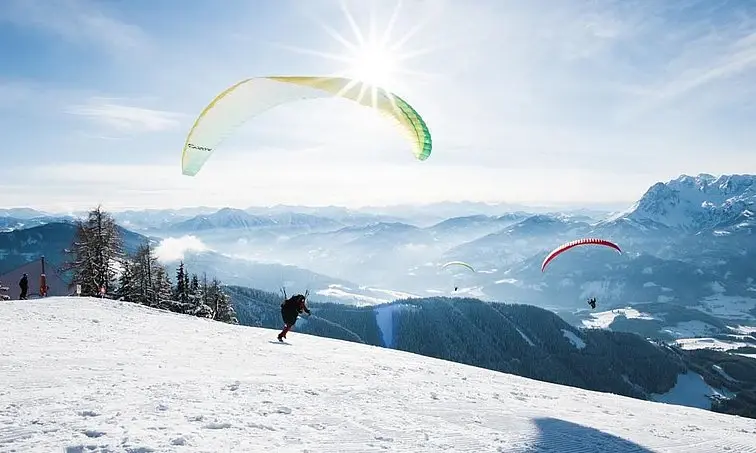 Group of people paragliding on a snowy mountain.