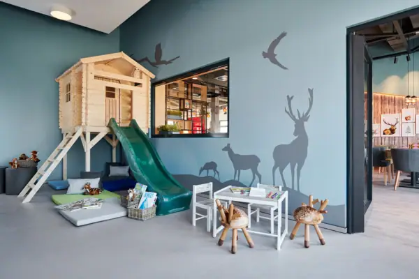 A room with a slide and a mural.