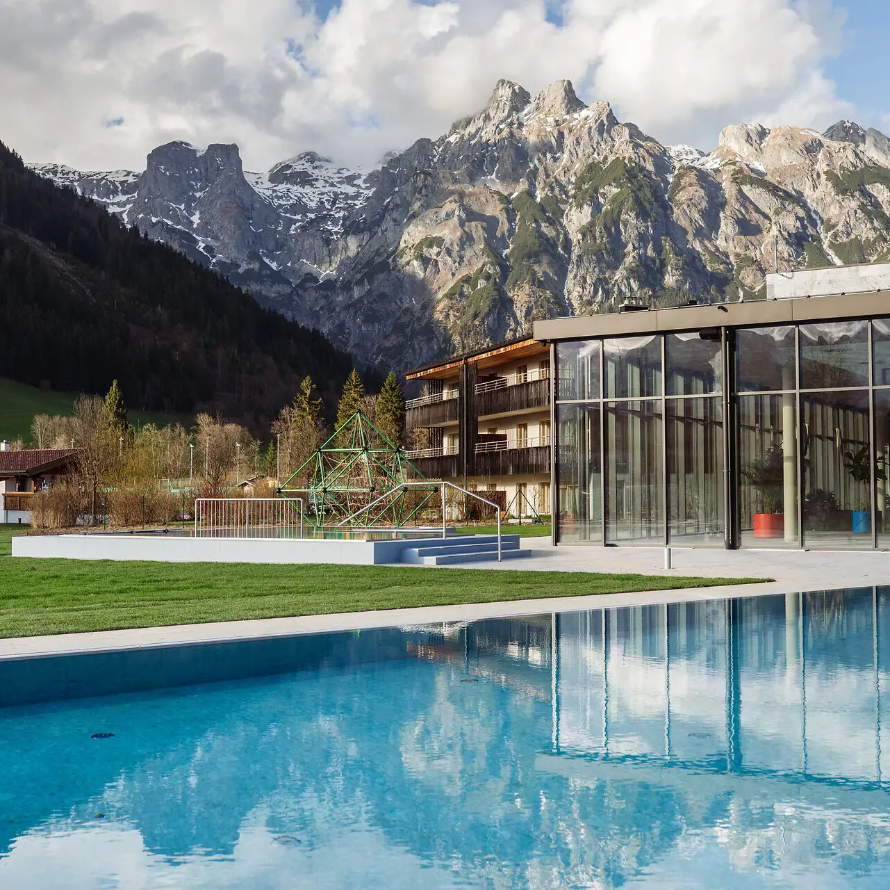 An outdoor swimming pool with a building in the background.