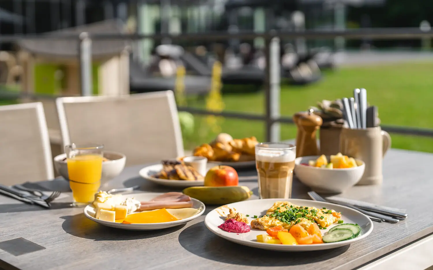 Table set with a variety of meals and drinks for brunch, including plates, platters, and dishware.