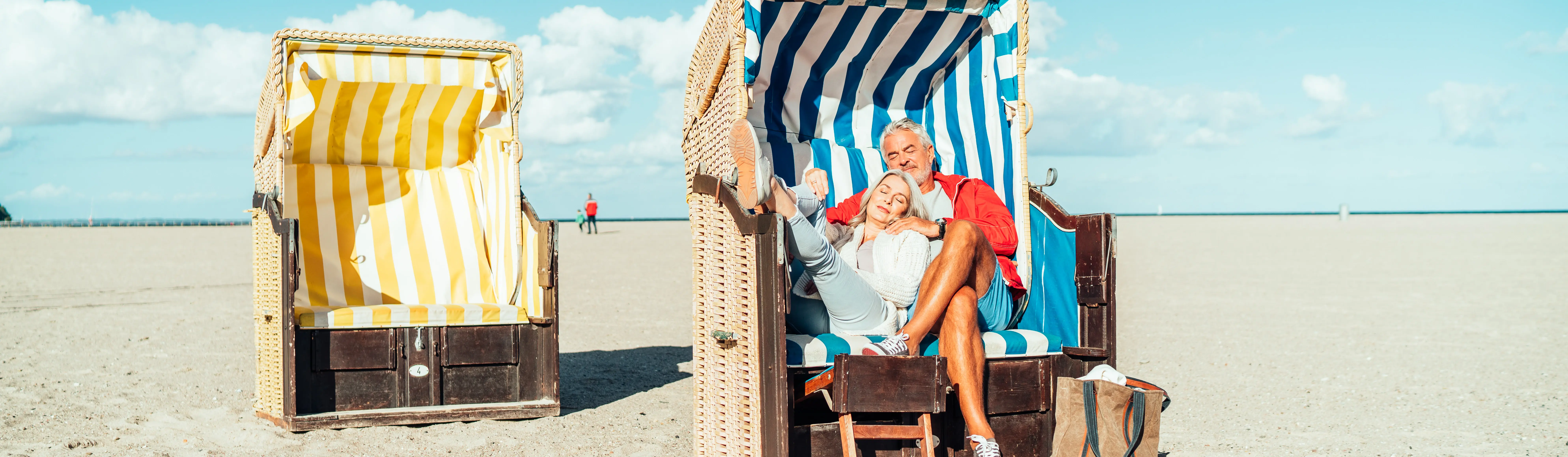 A couple relaxing in a beach chair in the sun on the beach.