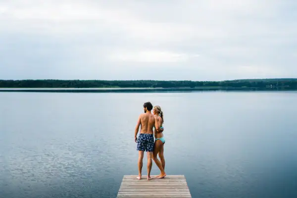 Scharmützelsee jetty A man and a woman are standing on a jetty in front of a lake.