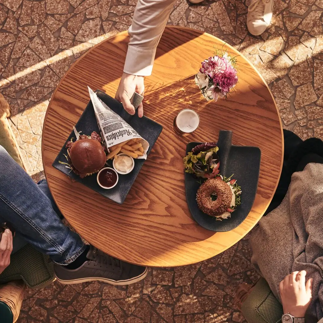 Person holding a plate of food on a table.
