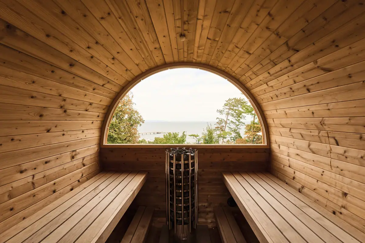 A room with a round window and a view of the ocean.