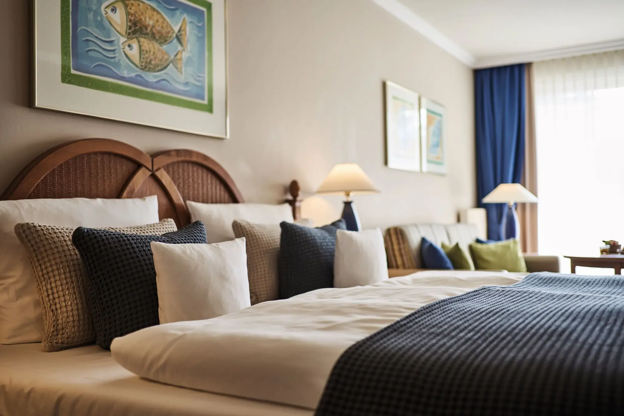 A bed with pillows and lamps in a room.