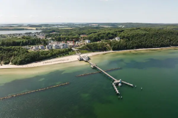 A jetty on a beach with a view of the water and the sky.