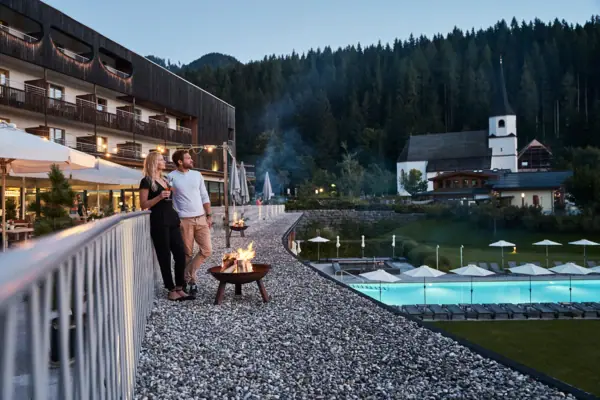 Terrace A man and a woman are standing next to a fire pit on the terrace of the aja Bergresort Werfenweng.