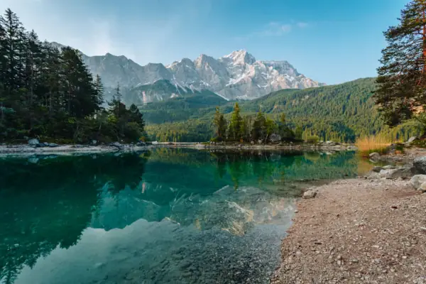 Eibsee A body of water with trees and mountains in the background.