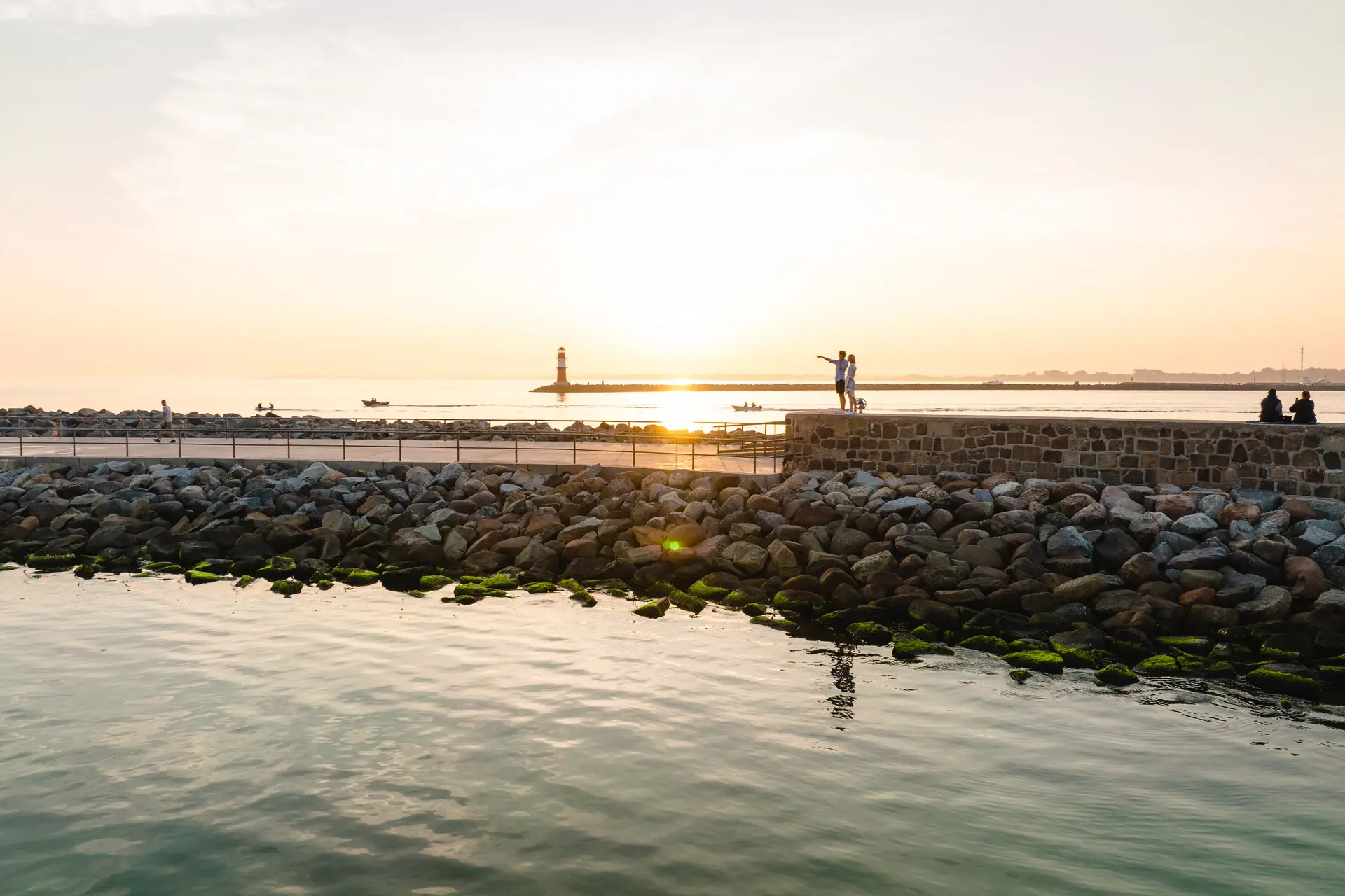 A group of people are standing by the water.