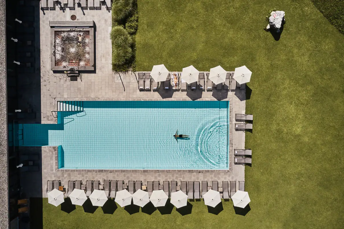 Swimming pool with parasols and lawn.