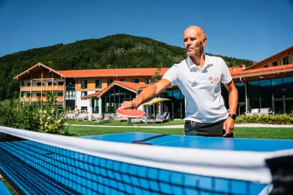 A man holds a tennis racket.
