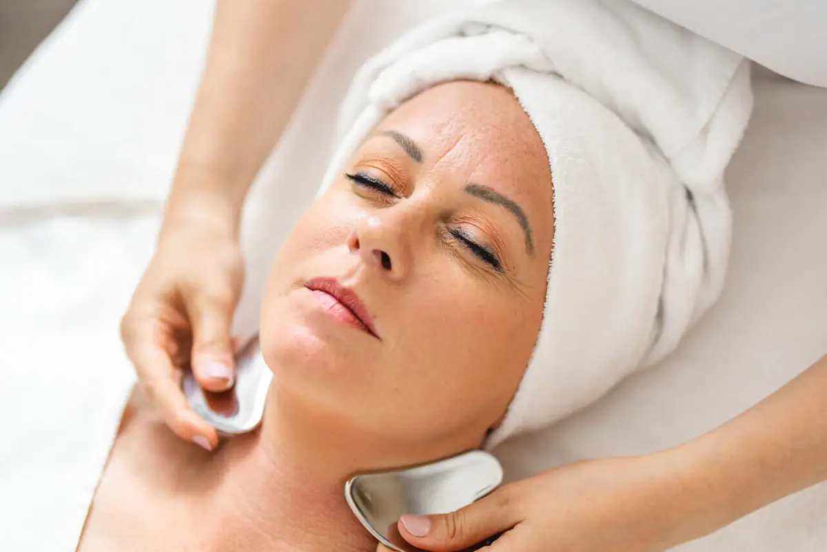 A woman receives a facial massage.
