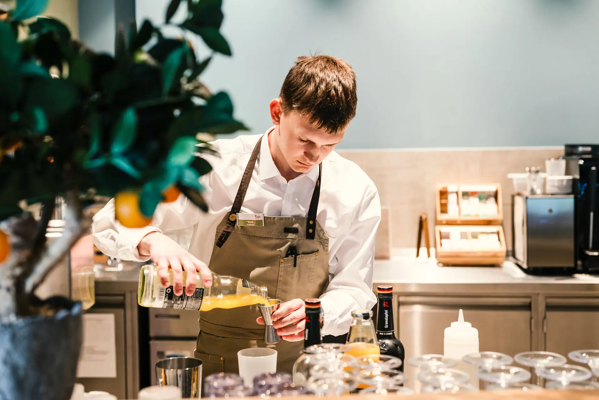 Bartender at the pool bar A man pours liquid into a glass.