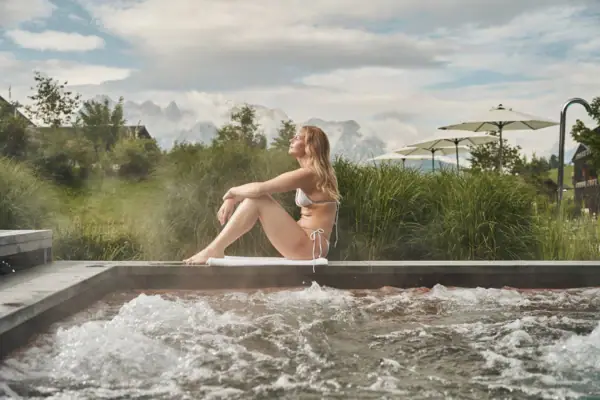 Woman sitting on the edge of a whirlpool.
