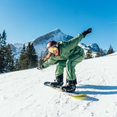 A person snowboarding in a snowy outdoor setting.