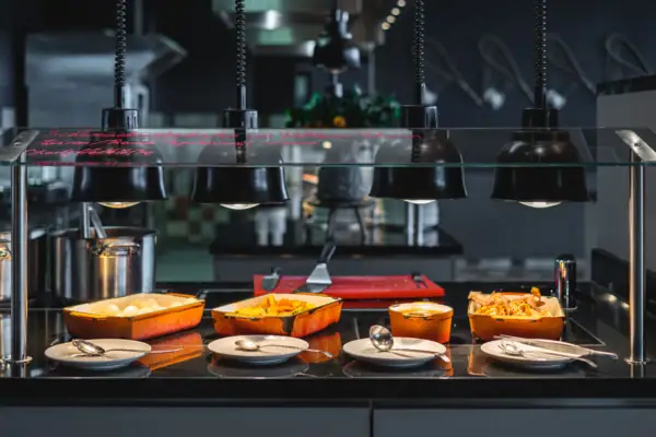 A buffet station with cast-iron pans filled with food.