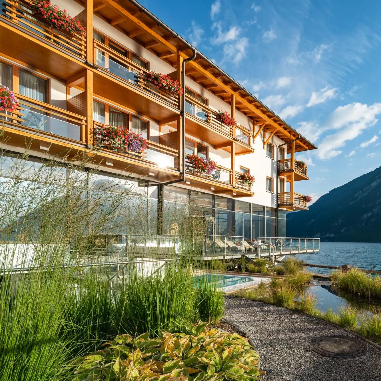Princely house on Lake Achensee A building with a lake and mountains in the background.