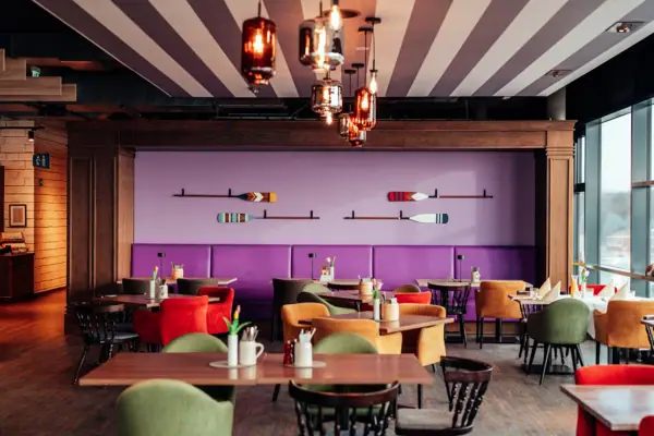 Room with tables and chairs, featuring furniture and interior design elements.