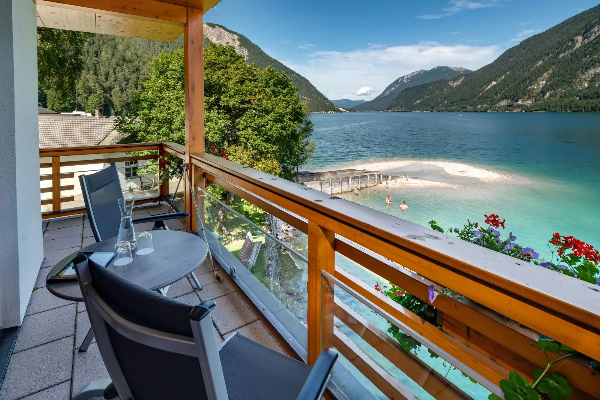 A balcony with table and chairs overlooking a body of water.