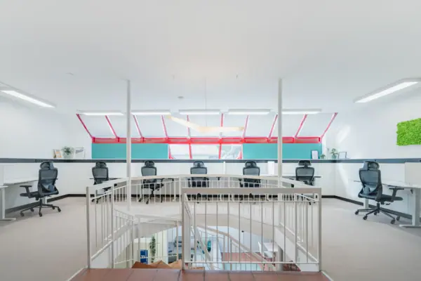 A white room with a staircase and chairs.