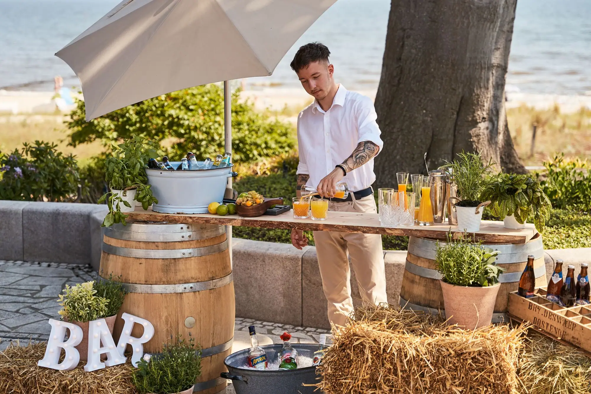 A man is standing at a table with drinks.