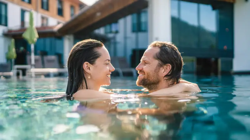 Couple in outdoor pool A man and woman relaxing in a swimming pool outdoors.