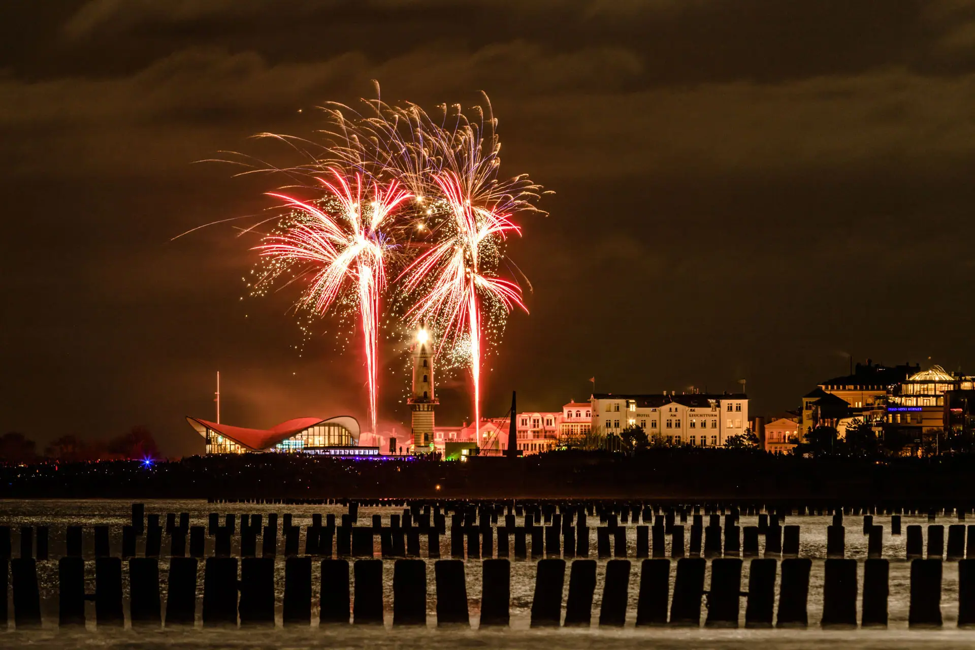 NYE Fireworks lighting up the night sky over a city.