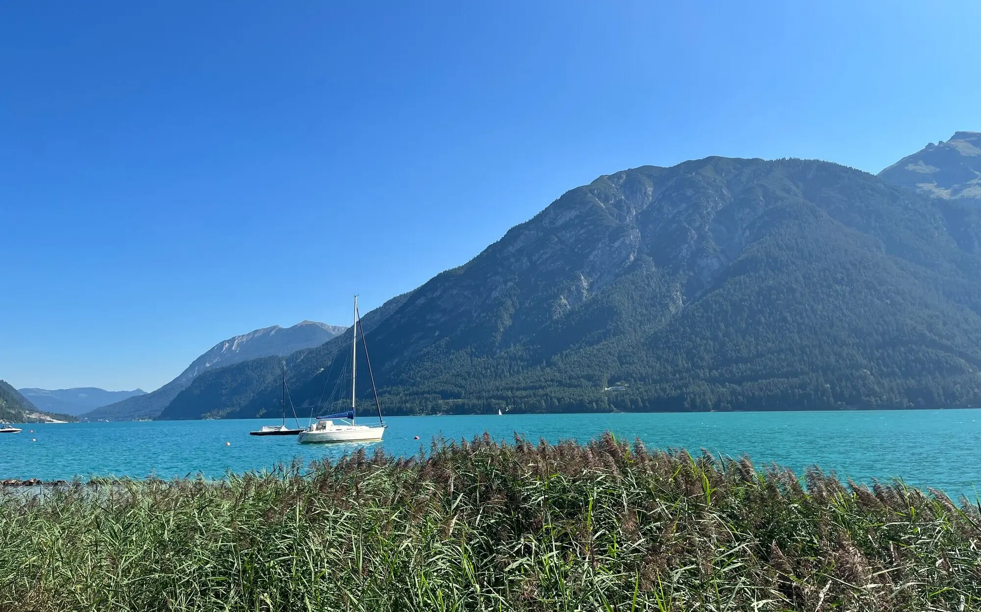 Sailing boat on a lake with mountains in the background.