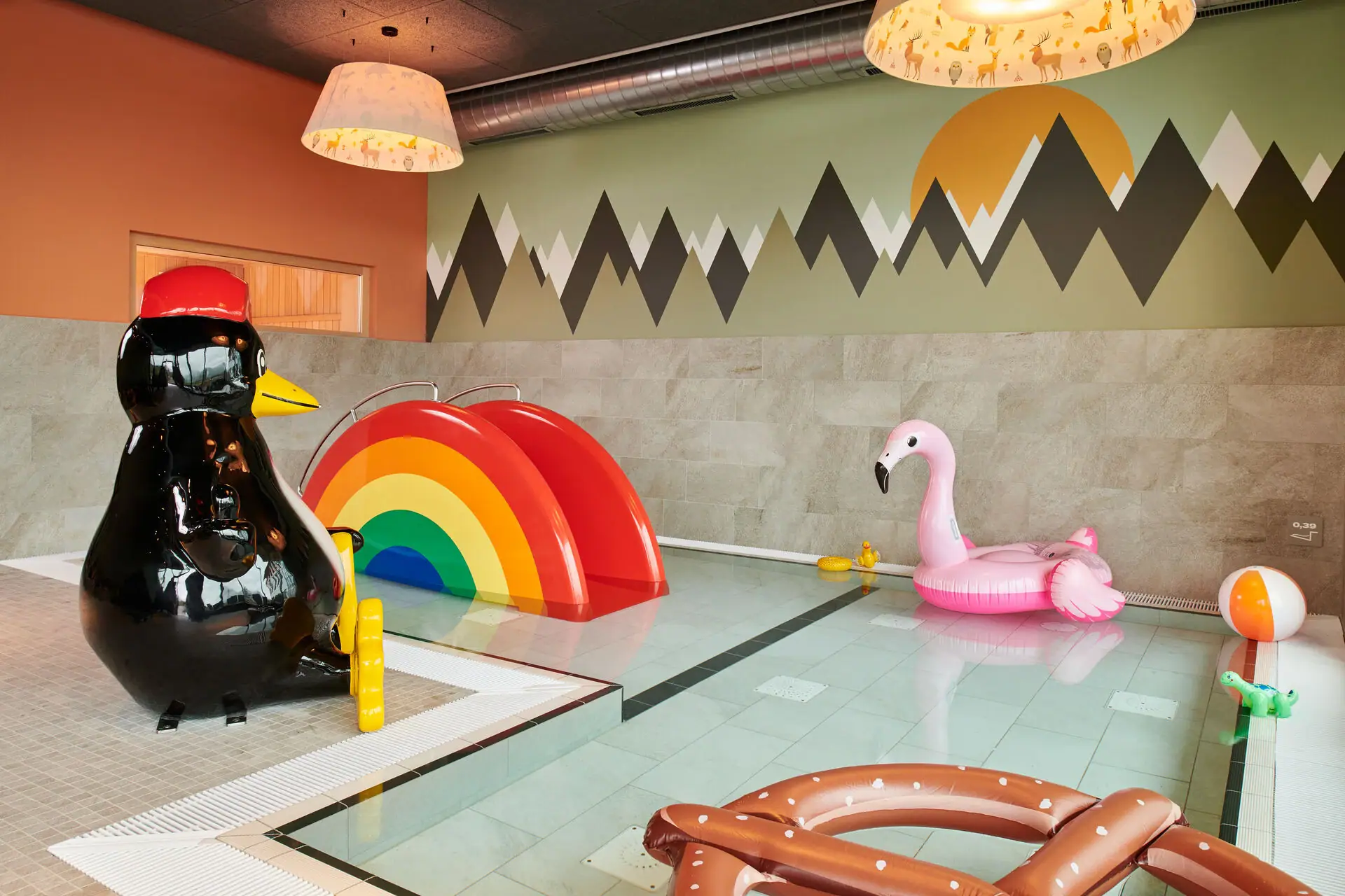 Children's area at the aja SPA Ruhpolding A pool with inflatable toys and a penguin.