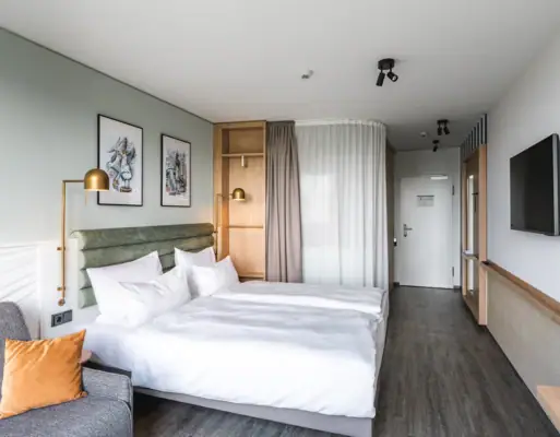 New rooms at aja Warnemünde Hotel room with double bed, pillows and bed linen.