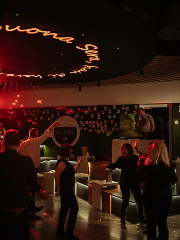 A group of people dance in a room.