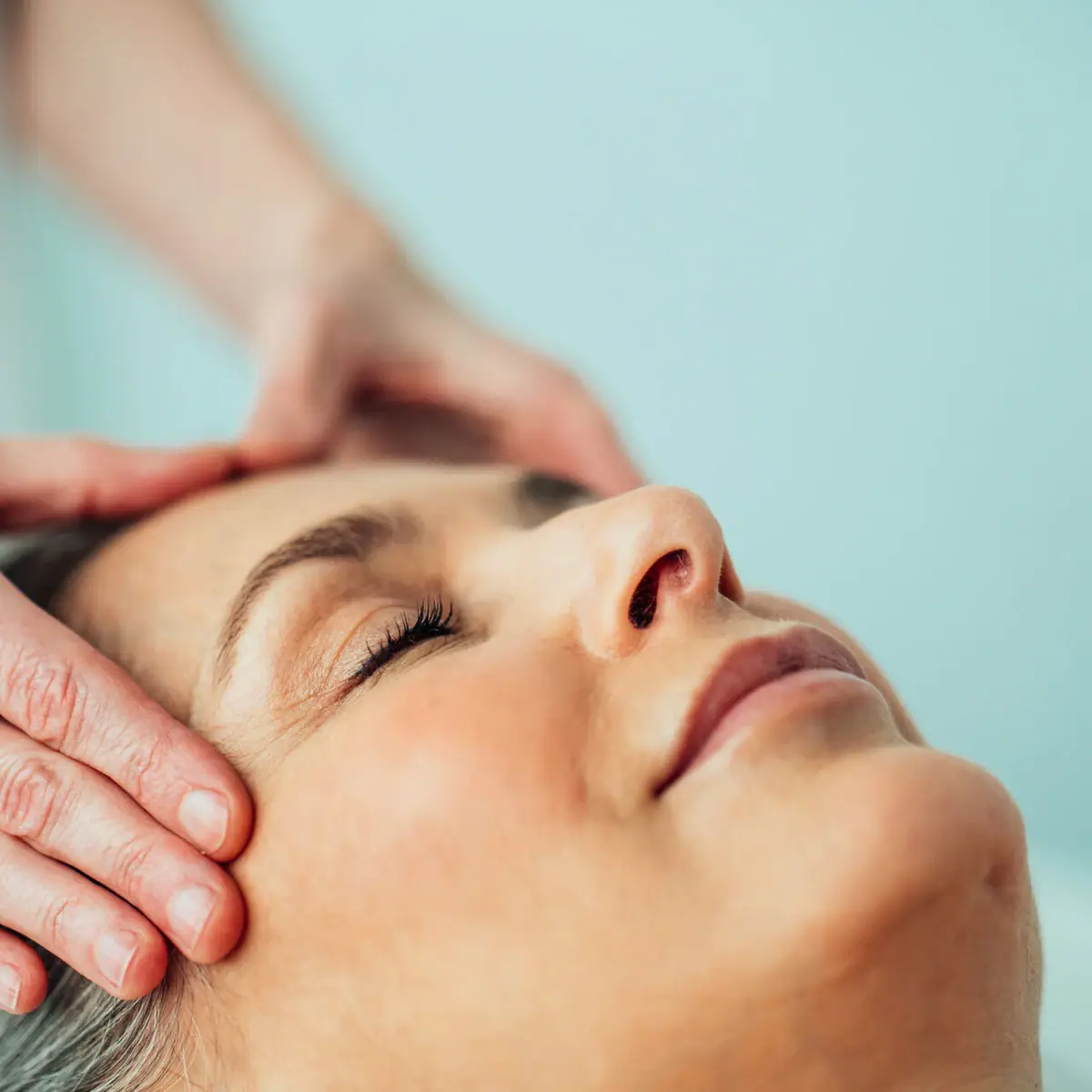 Head massage A person massages a woman's head.