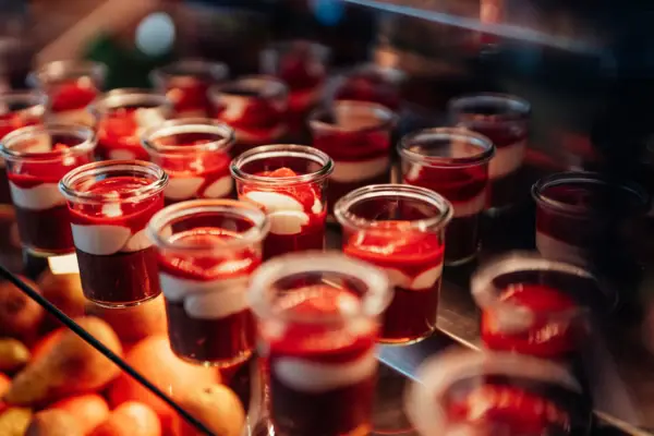 A group of glasses filled with desserts.