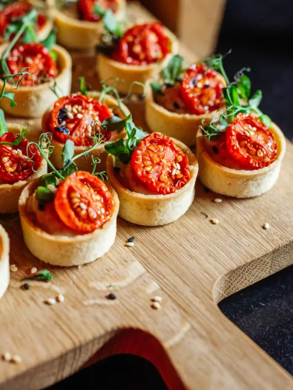 Small tartelettes with tomatoes on a board