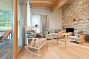 Living room with wooden floor and stone wall.