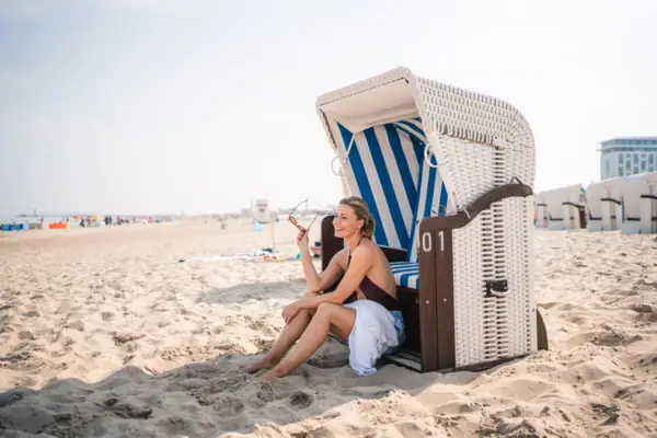 Woman sitting in a chair on the beach.