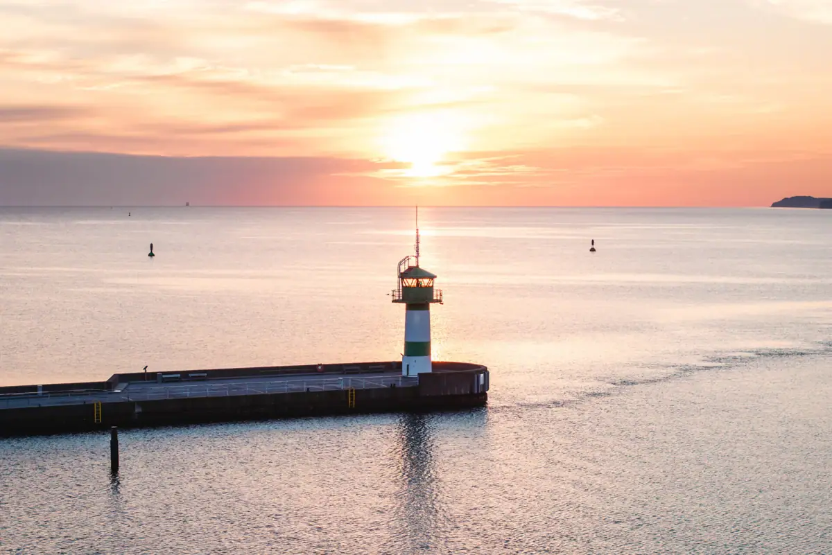 A pier with a lighthouse in the water.