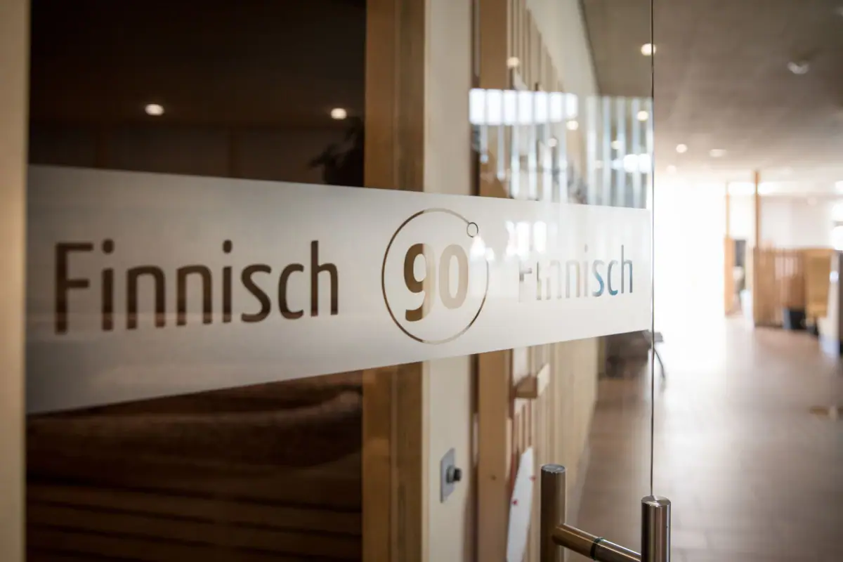 A sign on a glass door that reads Finnish sauna