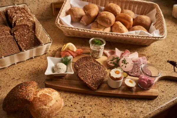 Cold cuts breakfast Wooden board with various baked goods on it.
