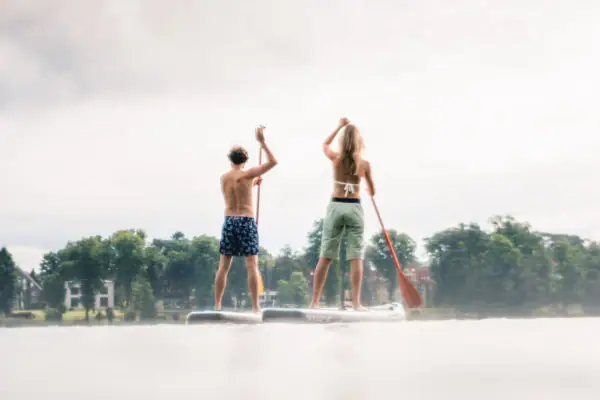 A man and a woman on a SUP board.