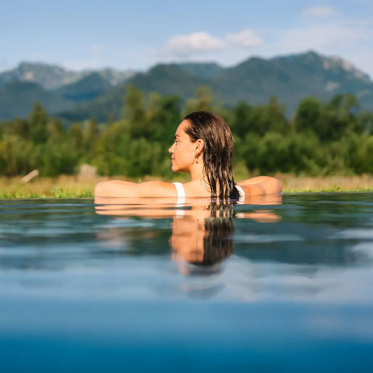 Outdoor pool aja Ruhpolding A woman in a pool of water.